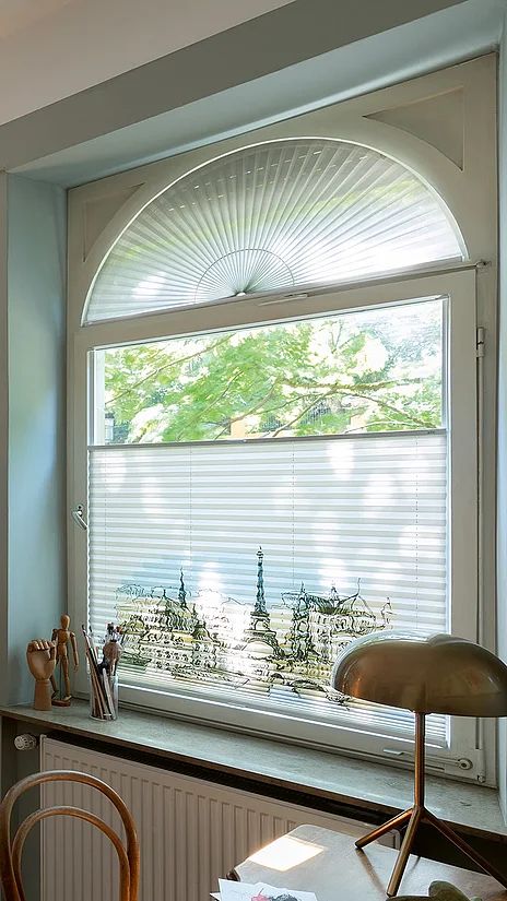 Plissees an einem Rundbogenfenster